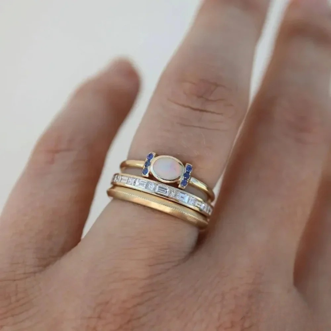 Theresa – Elegant guldring med skimrande opal och klara konturer.